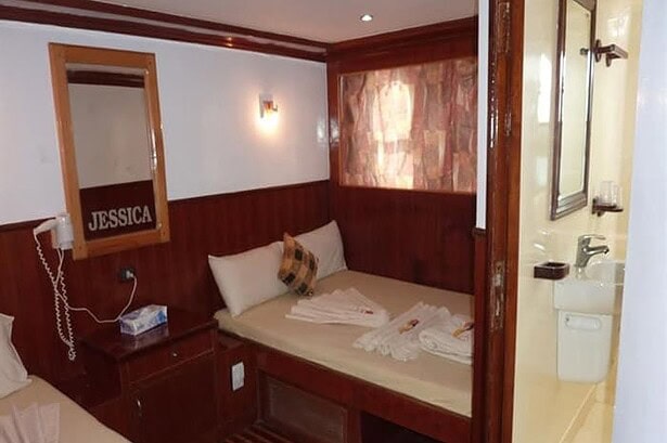 Cabin aboard the MY Jessica liveaboard with an ensuite bathroom visible through the doorway