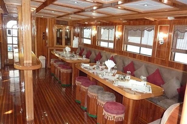 Dining saloon on the MY Jessica liveaboard with wood paneling and red velvet bar stools