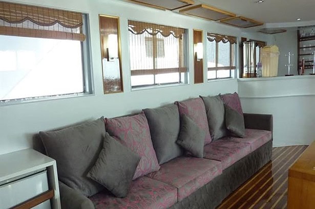 Lounge seating area on the MY Jessica liveaboard with patterned sofa cushions and wood floor
