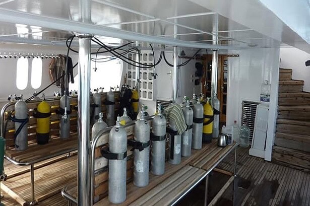 Scuba tanks racked on the dive deck of the MY Jessica liveaboard