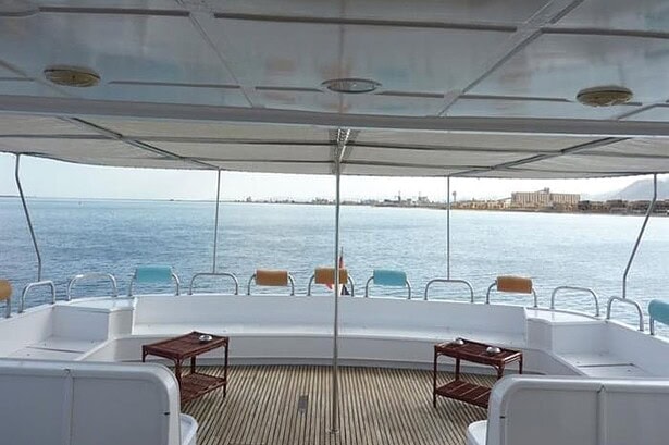 Shaded rear deck lounge aboard the My Jessica liveaboard with bench seating and a view of the Egyptian coast