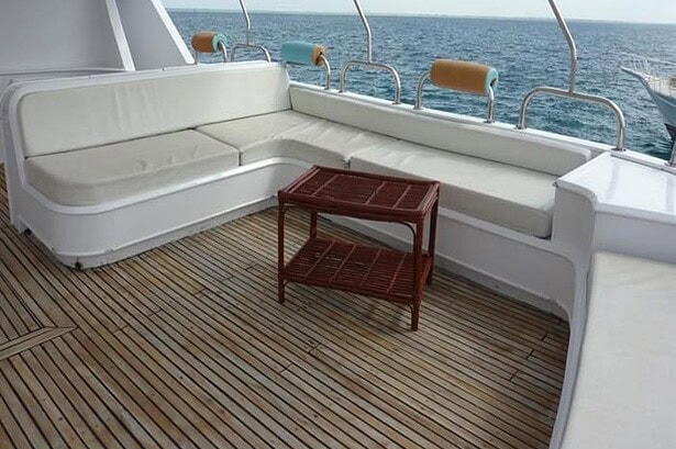 Sundeck lounge area on the MY Jessica liveaboard with white cushioned bench seating overlooking the sea
