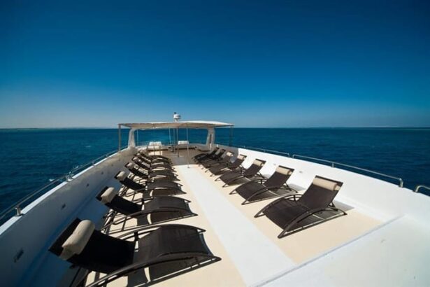 Open sun deck on a Red Sea liveaboard lined with lounge chairs and a shaded seating area at the bow
