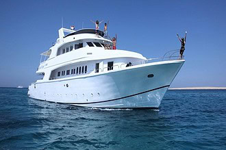 the bow of the liveaboard Blue Planet 1, with guests raising their arms from the deck