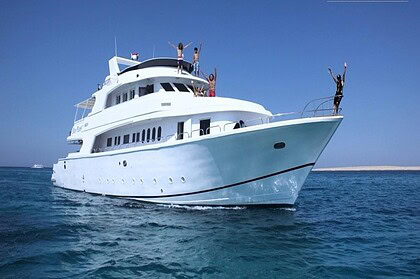 the bow of the liveaboard Blue Planet 1, with guests raising their arms from the deck