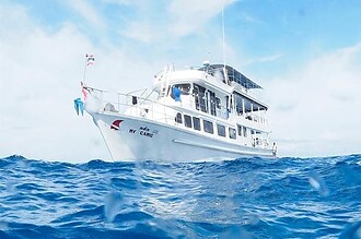 the liveaboard MV Camic cruising through choppy water, waves splashing in the foreground