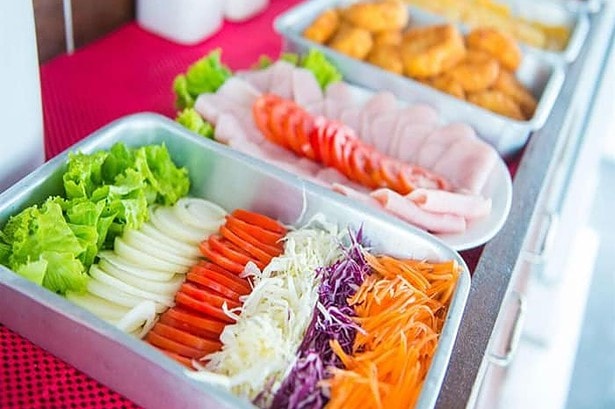 Buffet trays of salad, sliced ham and fried snacks laid out aboard the MV Camic liveaboard