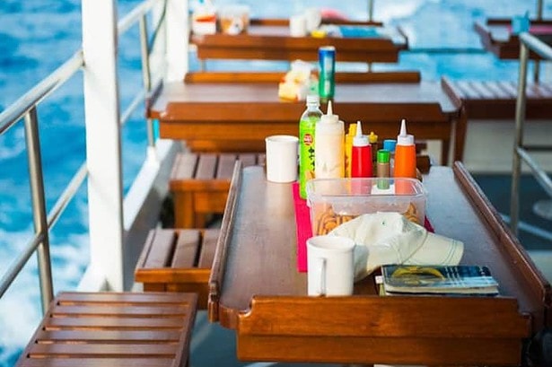 Condiments, snacks and coffee mugs set out on deck tables aboard the MV Camic between dives