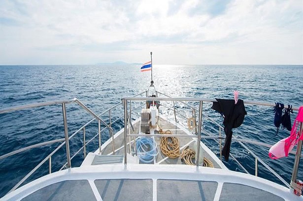 View from the bow of the MV Camic with wetsuits drying and the Similan Islands on the horizon