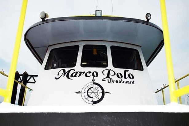 Bow of the MV Marco Polo liveaboard showing its name and compass rose logo