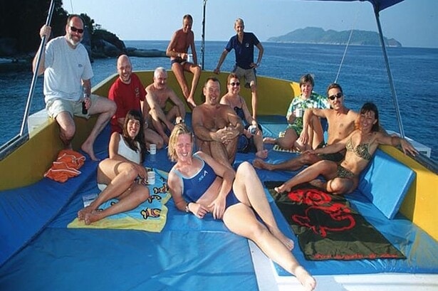 Group of divers smiling together on the MV Marco Polo's shaded sundeck