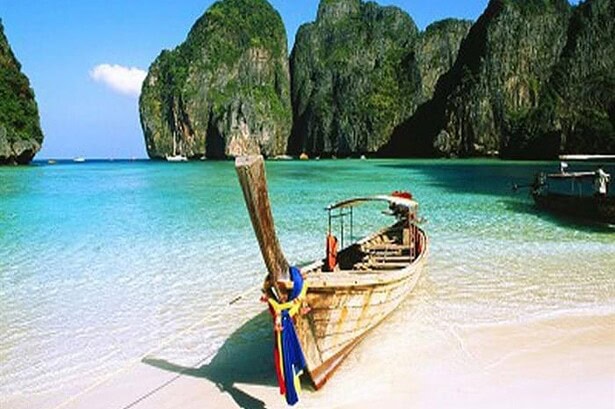 Traditional longtail boat beached at Maya Bay, Koh Phi Phi, framed by limestone cliffs