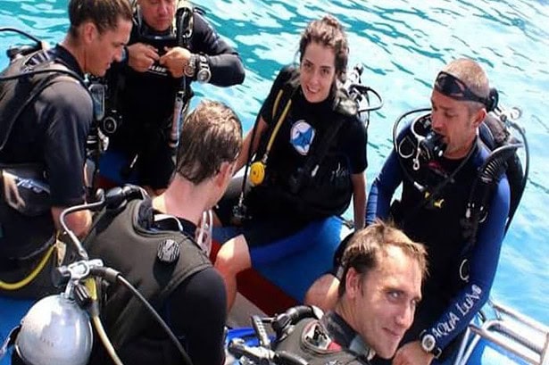 Scuba divers in full gear crowded onto the Oktavia's tender dinghy before a dive drop