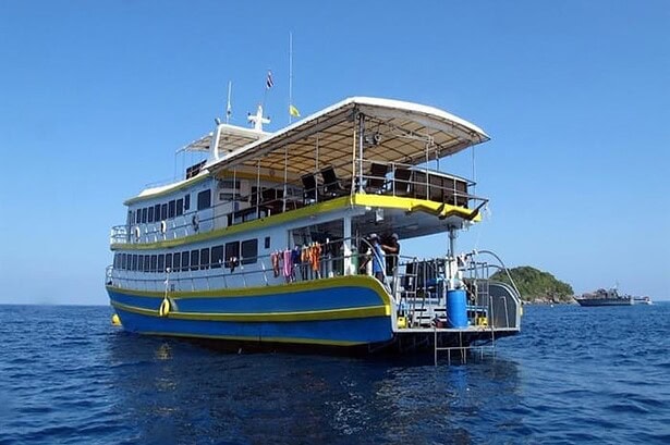 Stern view of the Oktavia liveaboard showing its sun deck, dive platform and a nearby island