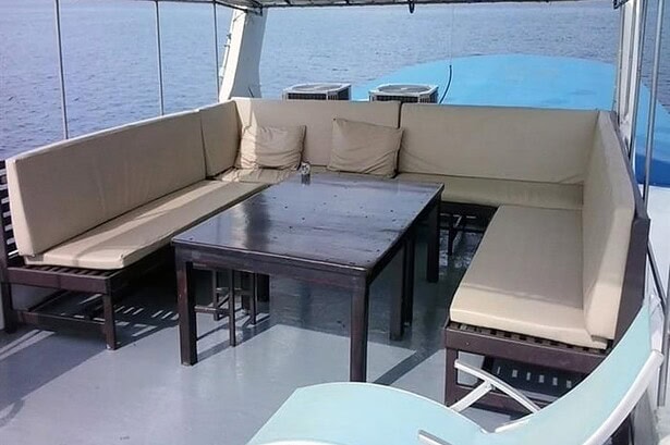Cushioned lounge seating around a table on the Oktavia's covered sun deck