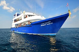 Manta Queen 3 liveaboard boat at anchor with a Thai flag flying from the bow