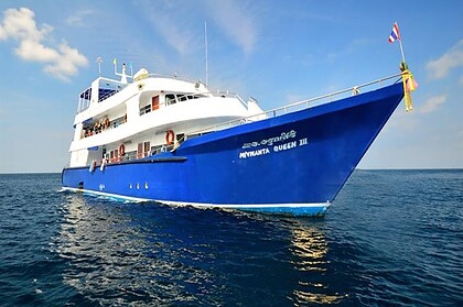 Manta Queen 3 liveaboard boat at anchor with a Thai flag flying from the bow