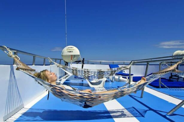 Guest relaxing in a hammock on the sun deck of the Manta Queen 3 liveaboard