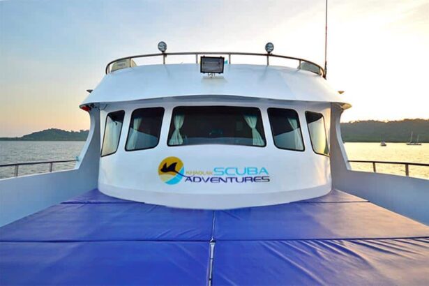 Bow of the Manta Queen 3 liveaboard with its wheelhouse and dive company logo at sunset