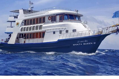 Manta Queen 8 liveaboard boat underway, cutting through waves with a full wake