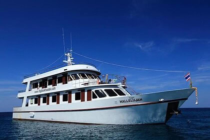The Hallelujah liveaboard cruising under blue skies with its name painted on the bow