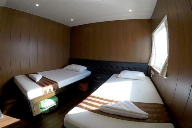Twin beds in a wood paneled cabin aboard the Infiniti liveaboard