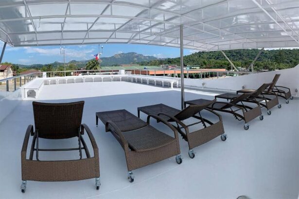 Shaded loungers line the covered sun deck aboard the Infiniti liveaboard, hills in the distance