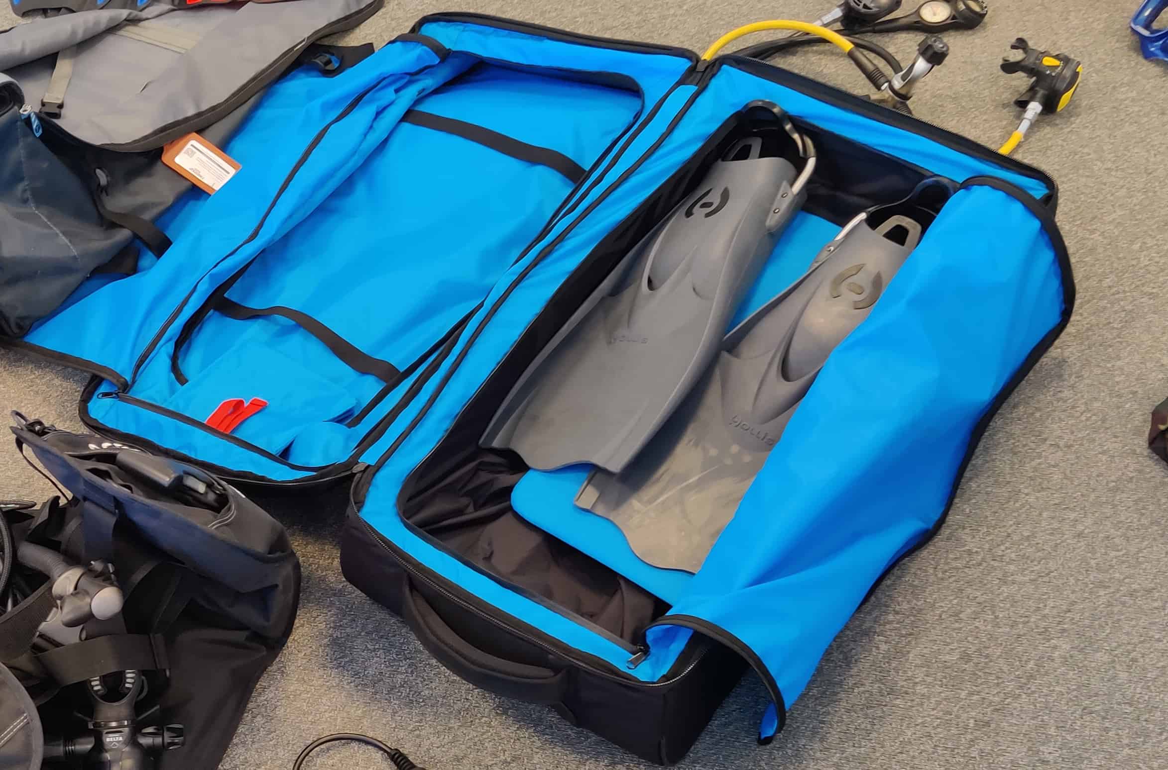 Open Stahlsac steel rolling dive bag with fins packed in the blue-lined second compartment