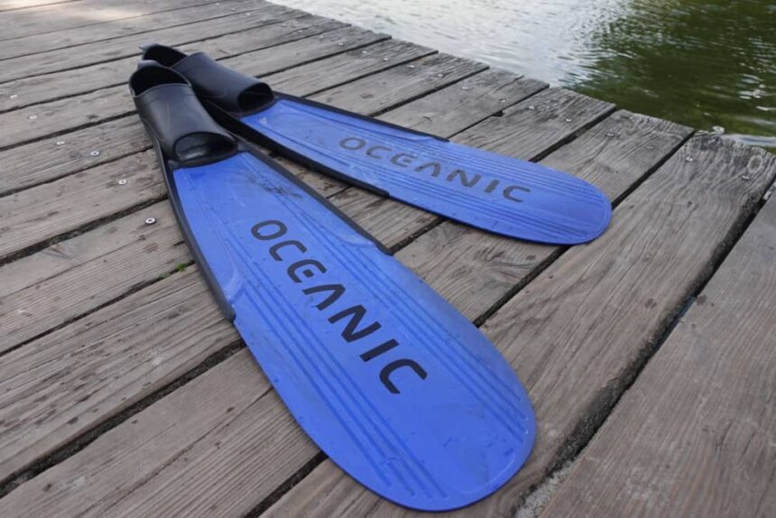 Oceanic Predator Freediving Fins Pair of blue Oceanic Predator full-foot fins lying on a wooden dock beside the water