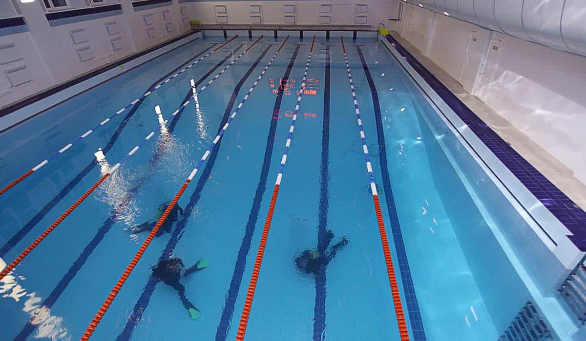 Overhead view of two scuba students training in lanes at an indoor pool