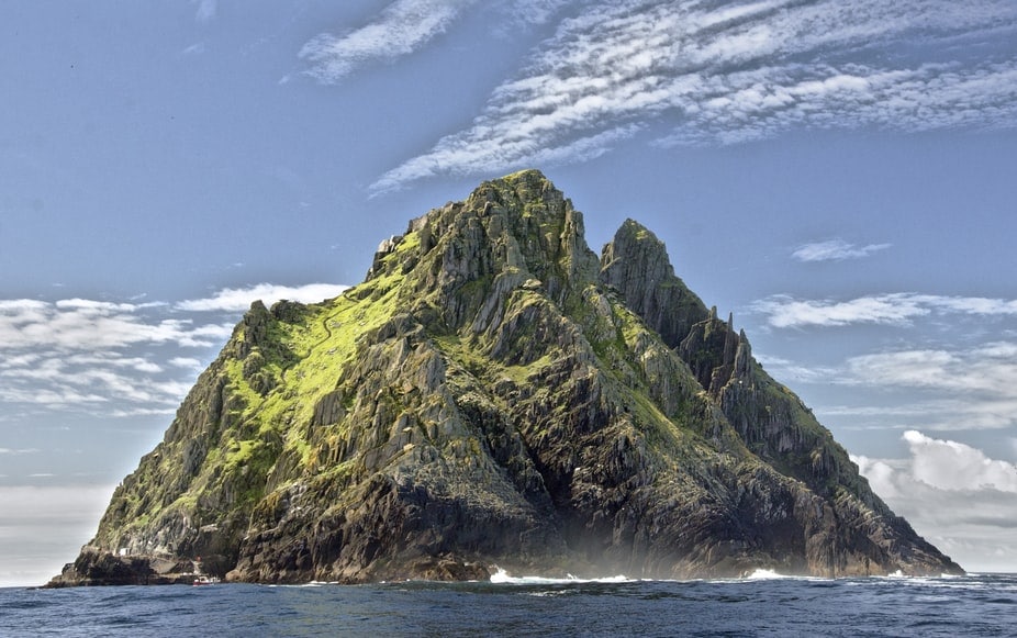 A rocky, moss covered island peak rises from the open ocean near Malpelo