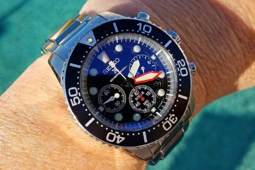 Our tester wearing the Seiko Chronograph SSC015P1 on the wrist beside sunlit pool water