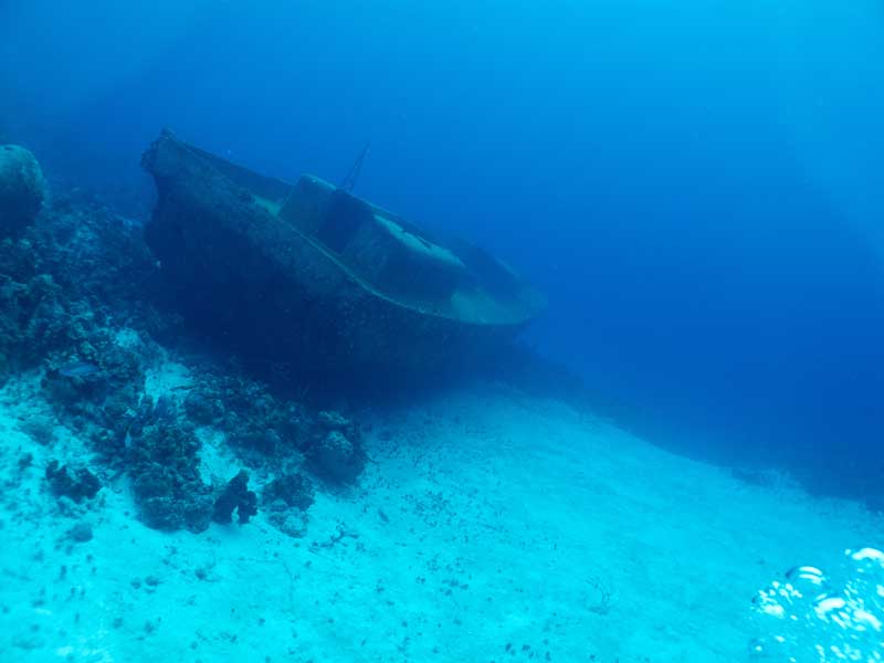 A rusted shipwreck rests on a sandy seabed off Cuba, a dive site flagged for health risks