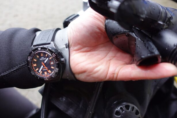 Our tester wearing the Delma Shell Star Black Tag while holding wet black dive gear in one hand