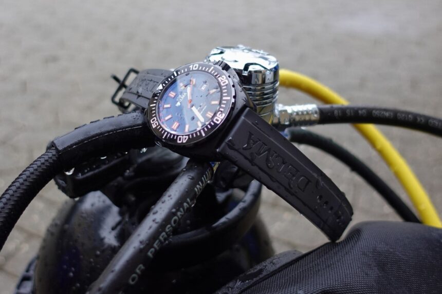 Delma Shell Star Black Tag On Regulator Delma Shell Star Black Tag dive watch resting on a wet scuba regulator beside a yellow hose