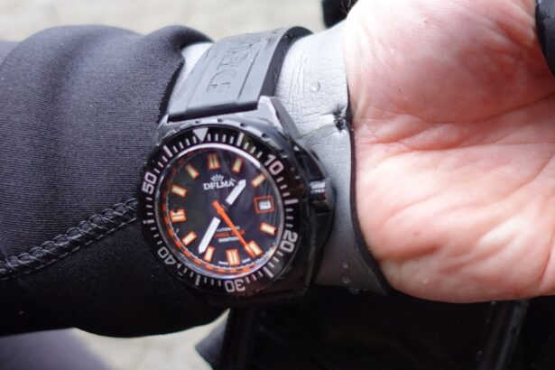 Close-up of the Delma Shell Star Black Tag on our tester's wrist over a black wetsuit sleeve