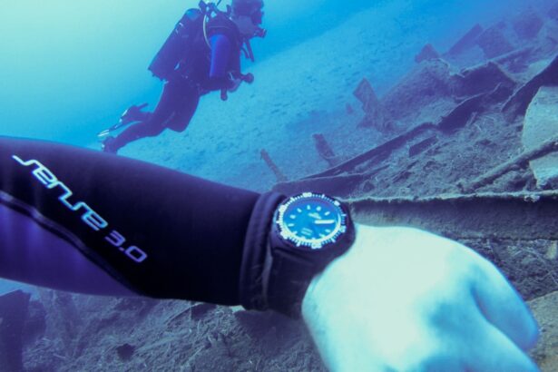 Our tester's wrist and dive watch above a sunken wreck with a second diver in the blue above