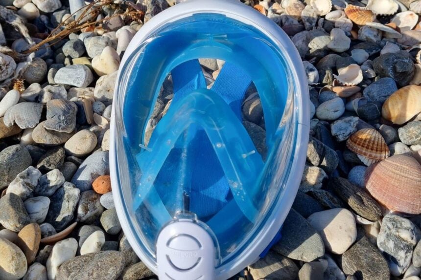 Subea Easybreath full face snorkel mask lying face up on a pebble beach