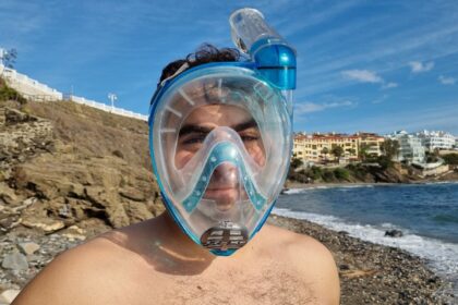 Our tester wearing the clear and blue Cressi Baron full face snorkel mask at the shoreline