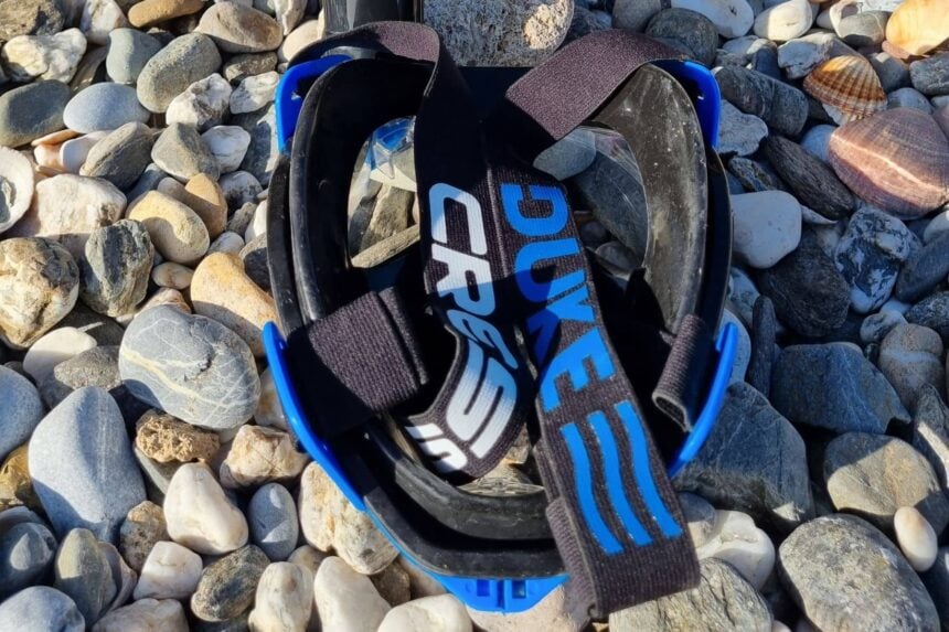 Cressi Duke Head Strap And Skirt Back of the Cressi Duke full face mask on pebbles with the padded head strap laid across the skirt