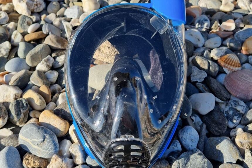 Cressi Duke Full Face Snorkel Mask Cressi Duke full face snorkel mask lying face up on a pebble beach, showing its clear single lens