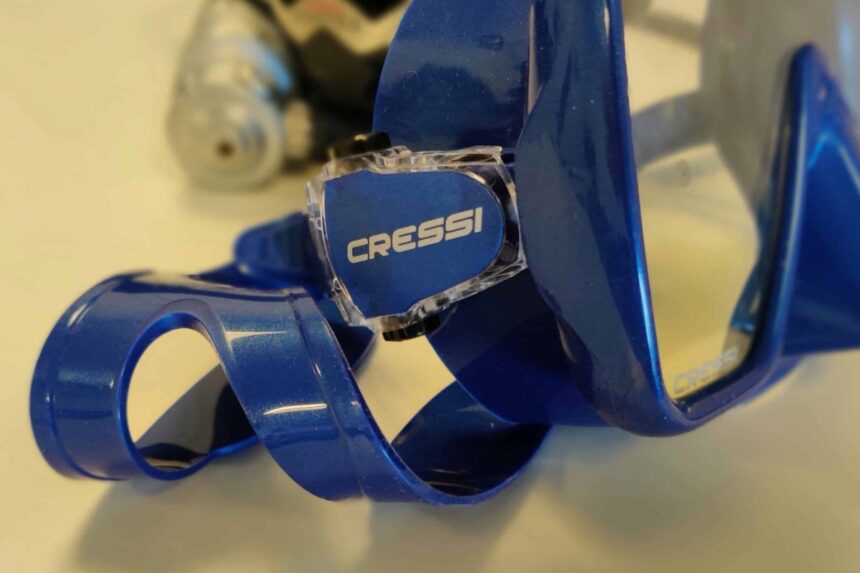 Cressi SF1 Strap and Buckle Detail Close-up of the Cressi SF1 blue silicone strap and quick-adjust buckle with a regulator behind it