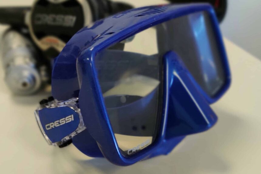 Cressi SF1 Blue Frameless Mask Angle Angled close-up of the blue Cressi SF1 frameless mask on a test bench with a regulator behind