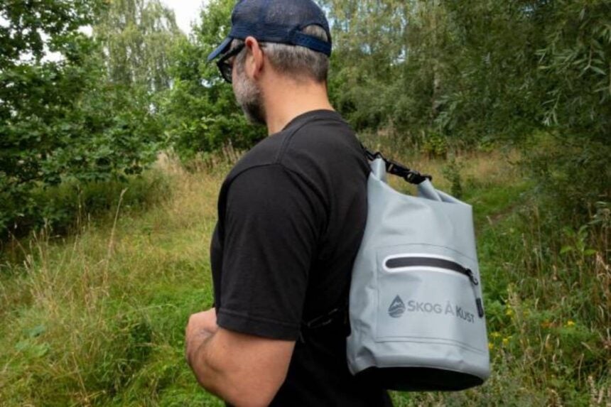 Skog A Kust DrySak Worn As Backpack Our tester wearing the gray Skog A Kust DrySak as a backpack on a grassy trail