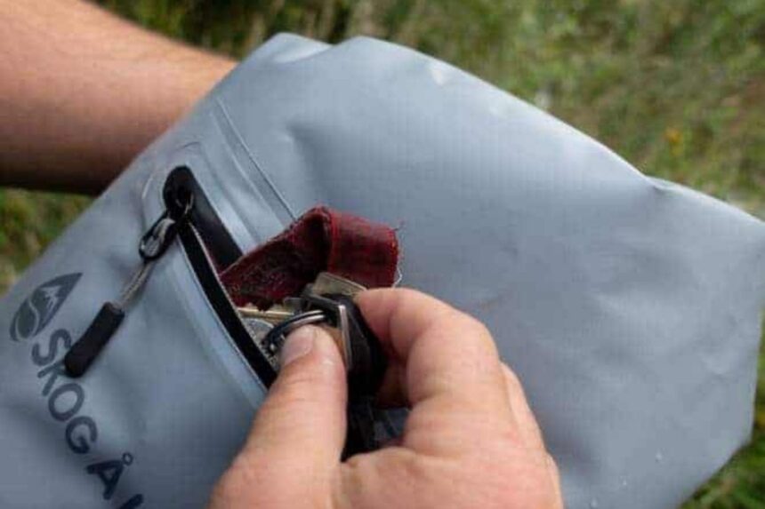 Skog Å Kust DrySåk Zip Pocket Our tester pulling keys from the lined external zip pocket of the grey Skog Å Kust DrySåk dry bag