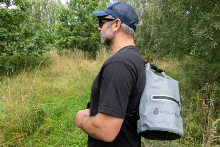 DrySak Roll Top Closed On The Trail Side view of our reviewer hiking with the Skog A Kust DrySak roll top strapped on