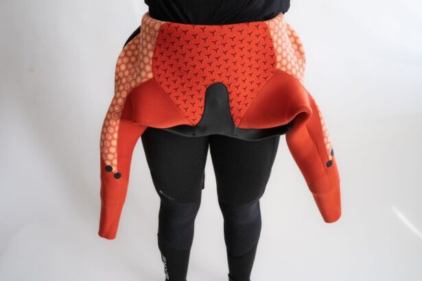 Bare Evoke wetsuit peeled down to the waist, showing the orange thermal lining inside the torso and sleeves