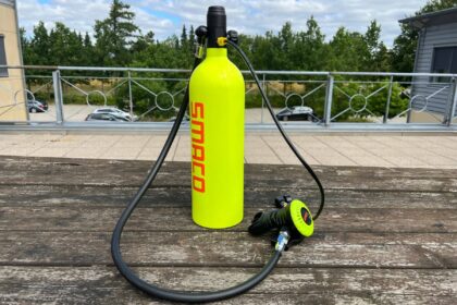 SMACO mini scuba tank with its hose and regulator set out on a wooden table before DIVEIN testing