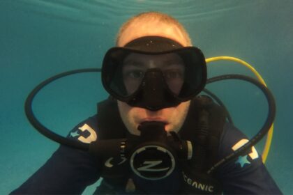 Our tester underwater in a pool wearing the Zeagle Scope Mono mask with a regulator in his mouth