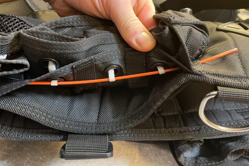 Zeagle Ripcord Weight Release Threading Our tester lifting the flap to show the orange Ripcord cord threaded through the weight pocket